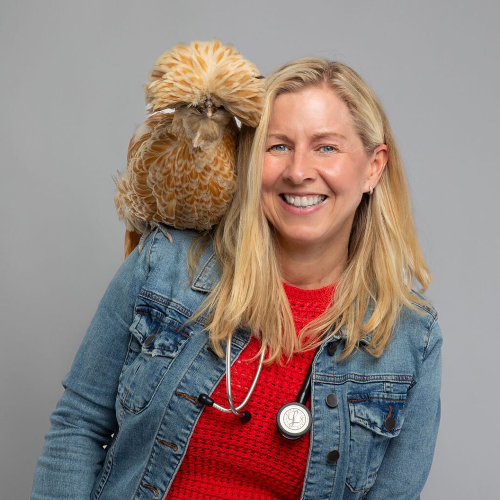 Dr Melissa Magnuson with a brown chicken perched on shoulder Dr Melissa Magnuson with a brown chicken perched on shoulder